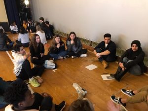 Students sitting in a circle sharing experiences.