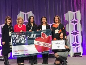 Five educators on stage receiving award.