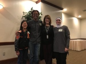 Former principal posing with three students