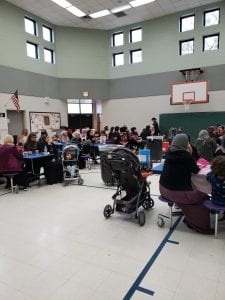 Families sitting in the Henry Ford Elementary cafeteria participating in Mother's Day breakfast.
